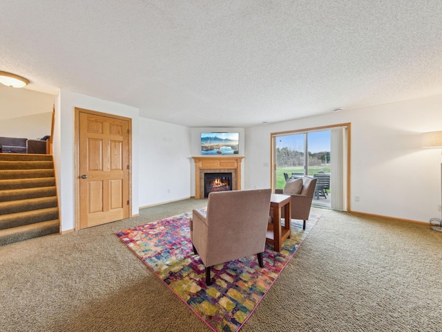 22184 Iman St NW, Nowthen, MN 55330 - living room featuring carpet flooring, stairs, a textured ceiling, a glass covered fireplace, and baseboards