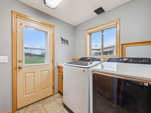 22184 Iman St NW, Nowthen, MN 55330 - laundry area with separate washer and dryer, cabinet space, plenty of natural light, a textured ceiling, and light tile patterned floors