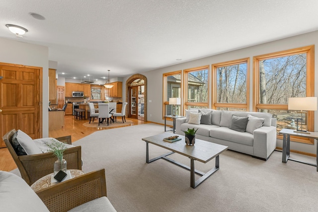 living room with recessed lighting, baseboards, and a textured ceiling