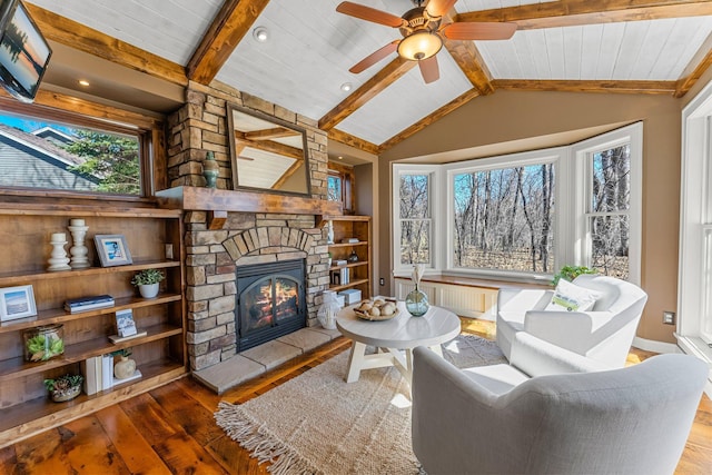 living room featuring a fireplace, wood-type flooring, vaulted ceiling with beams, and radiator