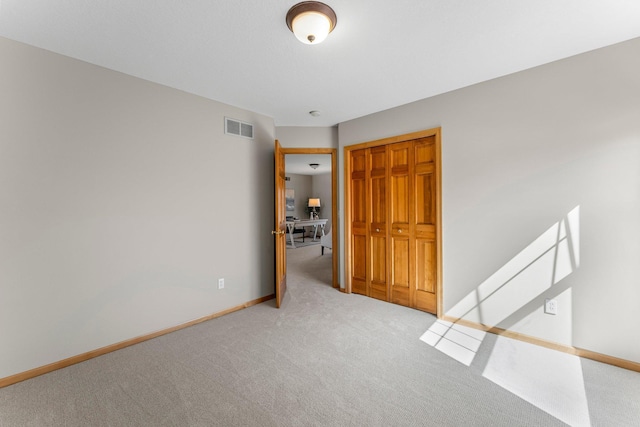 unfurnished room with visible vents, baseboards, and carpet floors