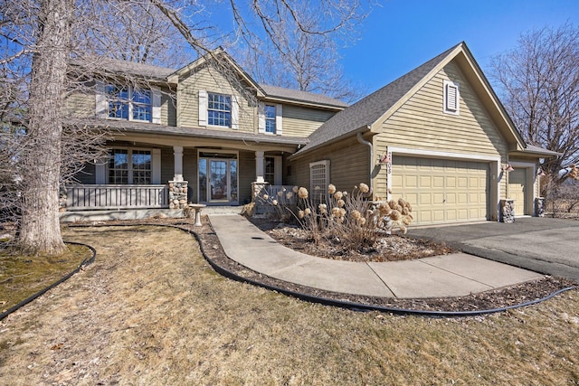 view of front facade with roof with shingles, an attached garage, covered porch, and aphalt driveway