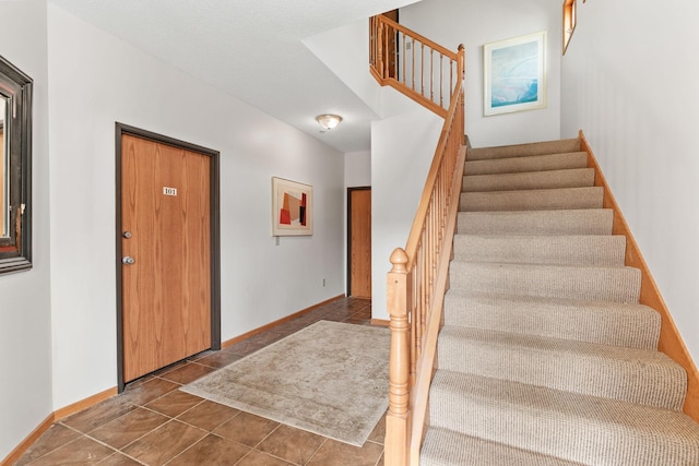 stairway featuring baseboards and tile patterned flooring