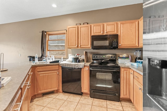 kitchen with light countertops, light tile patterned floors, light brown cabinets, and black appliances