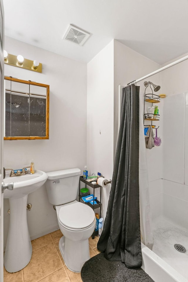bathroom featuring toilet, a stall shower, tile patterned floors, and visible vents