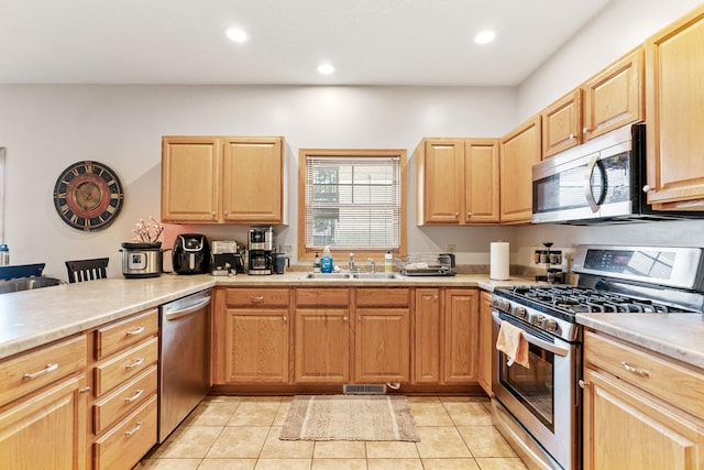 kitchen featuring light countertops, a sink, appliances with stainless steel finishes, and recessed lighting