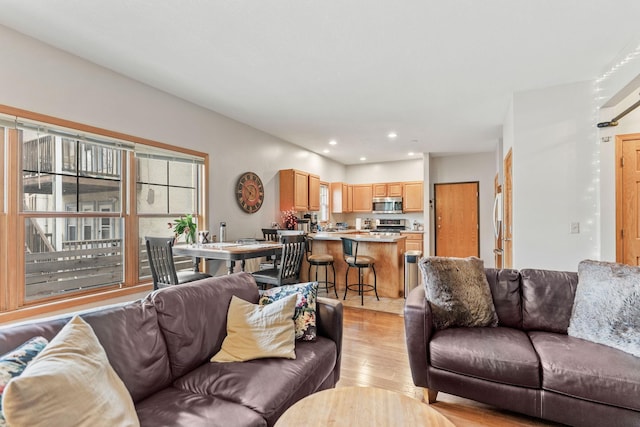 living area with light wood-style flooring and recessed lighting