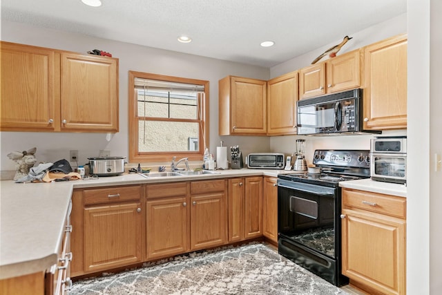 kitchen featuring light countertops, recessed lighting, a sink, light brown cabinets, and black appliances