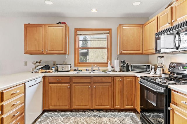kitchen featuring light countertops, a toaster, recessed lighting, a sink, and black appliances