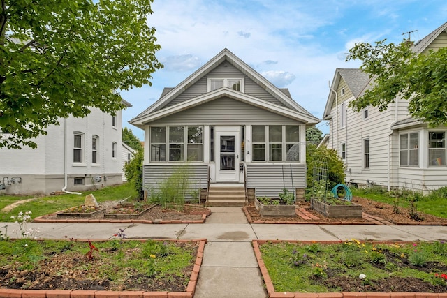 851 Watson Ave, Saint Paul, MN 55102 - view of front facade with a vegetable garden and a sunroom