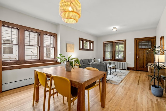851 Watson Ave, Saint Paul, MN 55102 - dining area featuring radiator, a baseboard heating unit, and light wood-style flooring