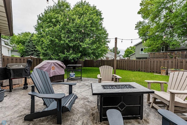 view of patio / terrace with grilling area, an outdoor fire pit, and a fenced backyard