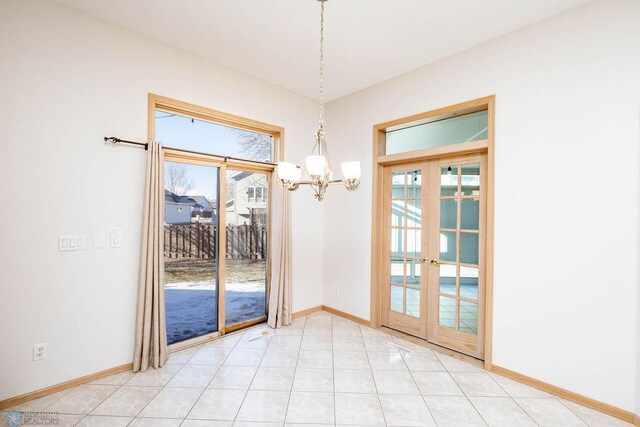 interior space featuring light tile patterned floors, french doors, baseboards, and a chandelier