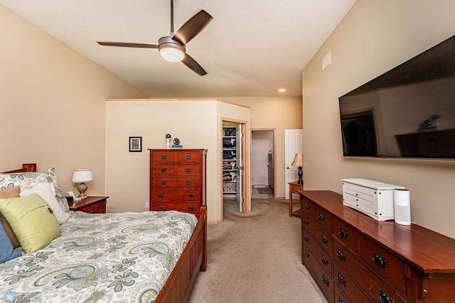 bedroom with a spacious closet, visible vents, light carpet, a closet, and a ceiling fan