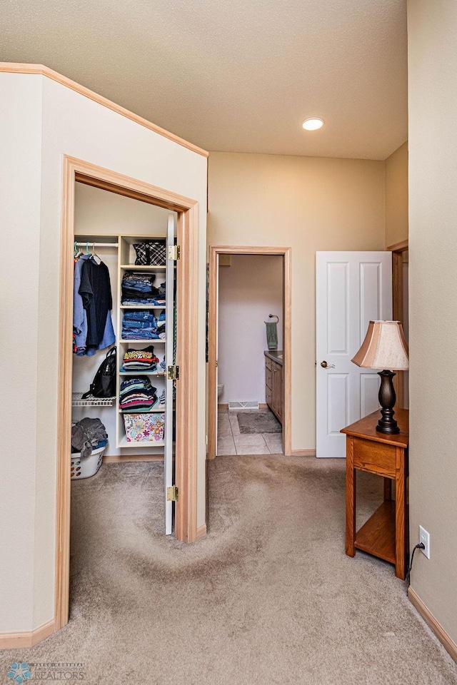 corridor featuring carpet flooring, a textured ceiling, and baseboards
