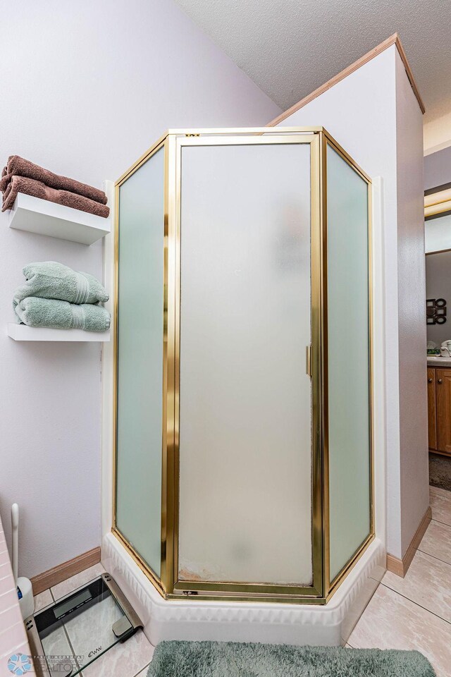 bathroom featuring tile patterned floors, lofted ceiling, a textured ceiling, and a stall shower