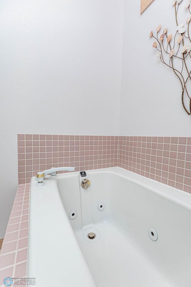 bathroom with a tub with jets