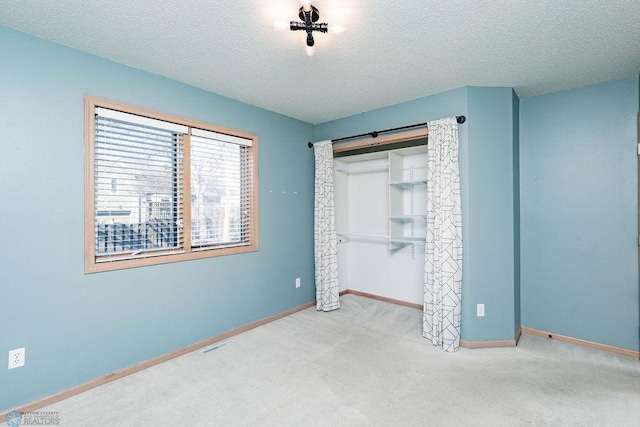unfurnished bedroom featuring carpet flooring, baseboards, and a textured ceiling
