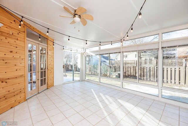 unfurnished sunroom with a ceiling fan, track lighting, and french doors