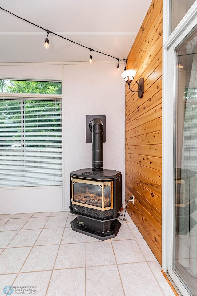 interior details with wooden walls, rail lighting, and a wood stove