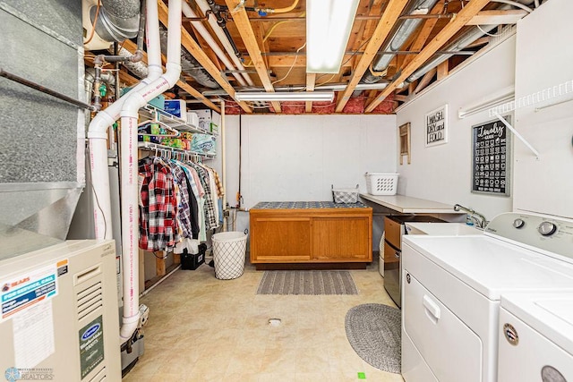 unfinished basement featuring a sink, heating unit, and washing machine and clothes dryer