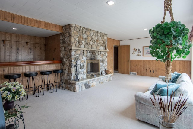 17639 Gayle Dr, Little Falls, MN 56345 - carpeted living area featuring visible vents, a dry bar, a fireplace, wainscoting, and wood walls