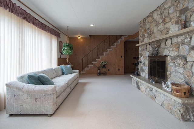 17639 Gayle Dr, Little Falls, MN 56345 - carpeted living area featuring wood walls, a fireplace, and stairs