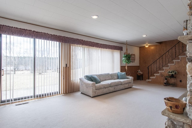 17639 Gayle Dr, Little Falls, MN 56345 - carpeted living room with wooden walls, stairs, and visible vents