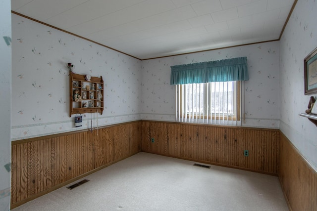 17639 Gayle Dr, Little Falls, MN 56345 - empty room featuring visible vents, ornamental molding, a wainscoted wall, and wooden walls