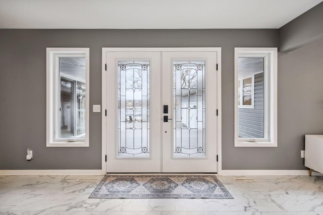 doorway to outside featuring marble finish floor, baseboards, and french doors