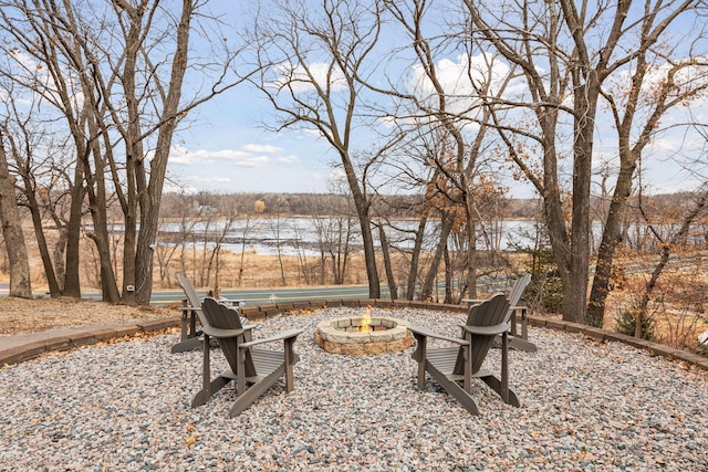 view of yard with an outdoor fire pit and a water view