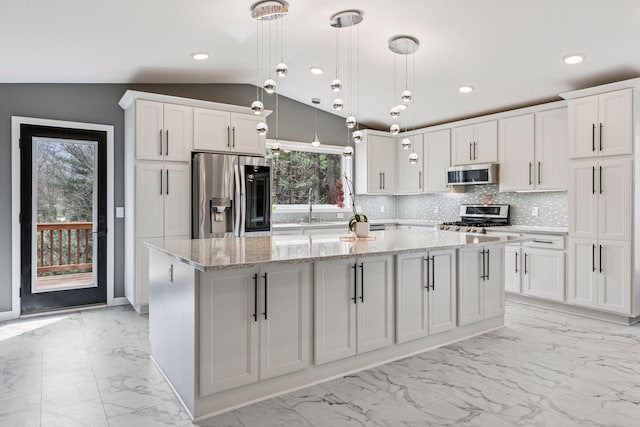 kitchen featuring marble finish floor, lofted ceiling, decorative backsplash, and stainless steel appliances