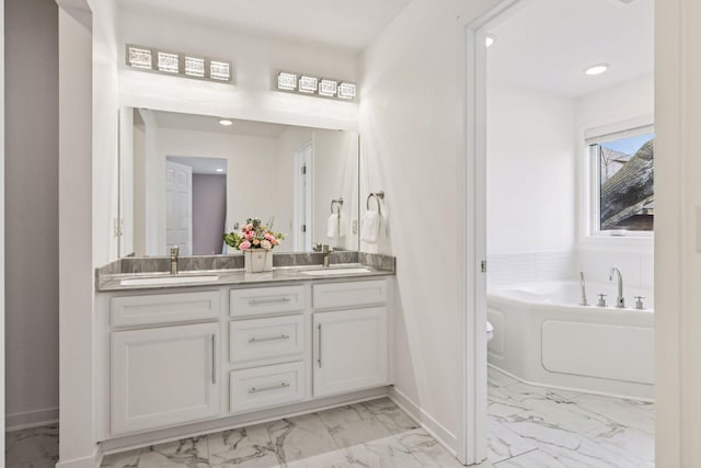 bathroom featuring marble finish floor, a sink, double vanity, and baseboards