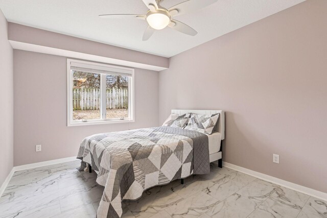 bedroom featuring baseboards, marble finish floor, and a ceiling fan