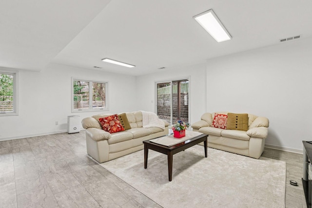 living area with baseboards and visible vents