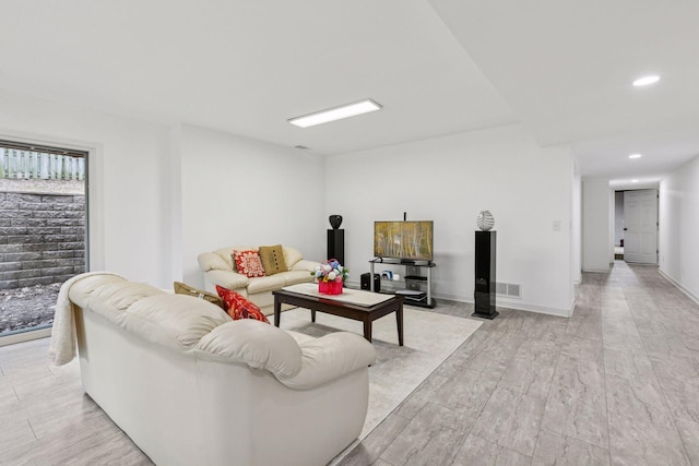 living area featuring baseboards, visible vents, recessed lighting, and light wood finished floors