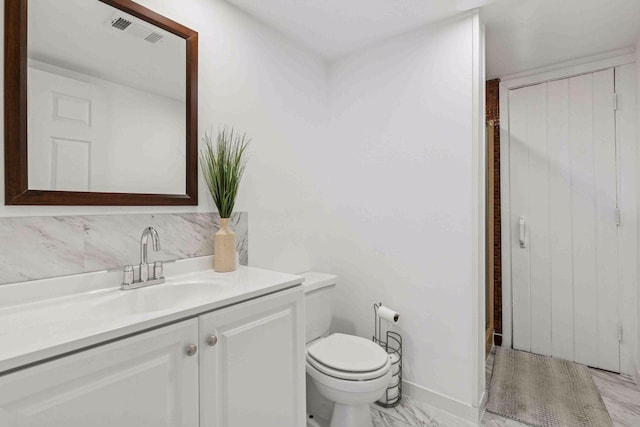 bathroom with toilet, vanity, decorative backsplash, and visible vents