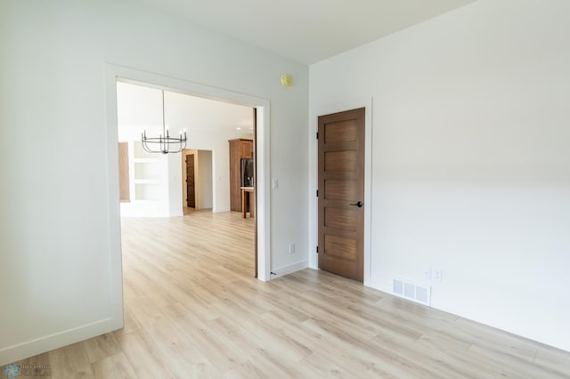 662 Rania Way W, West Fargo, ND 58078 - empty room featuring a chandelier and light wood-style floors