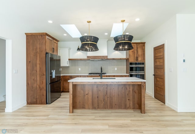 662 Rania Way W, West Fargo, ND 58078 - kitchen featuring refrigerator with ice dispenser, a skylight, light wood-style flooring, and recessed lighting