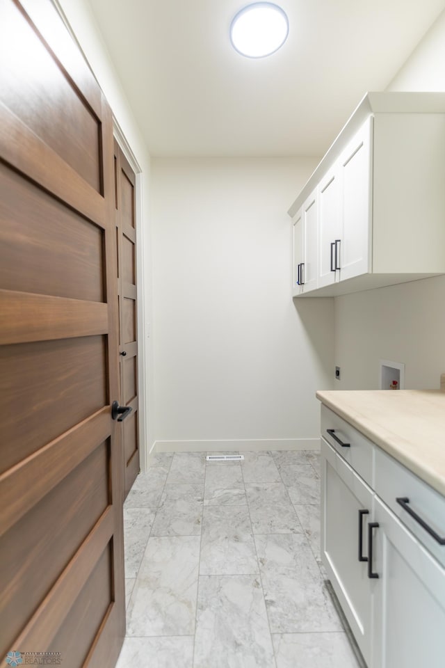 662 Rania Way W, West Fargo, ND 58078 - laundry room featuring light marble finish flooring, cabinet space, electric dryer hookup, and washer hookup