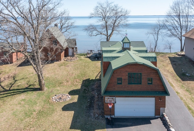 exterior space featuring an attached garage, a gambrel roof, a front yard, a water view, and driveway