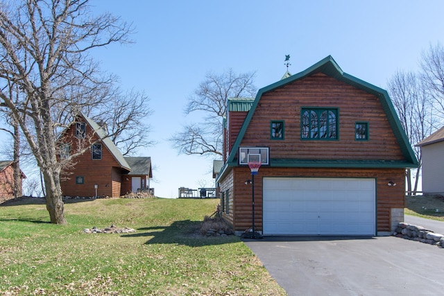 view of side of property with an attached garage, a yard, a gambrel roof, and aphalt driveway