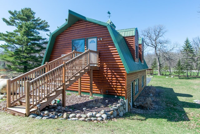 view of side of home featuring stairway, a lawn, metal roof, and a gambrel roof
