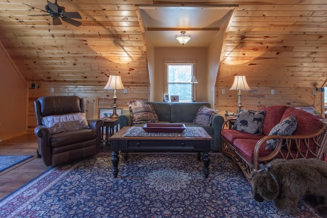 living room featuring a ceiling fan, wood finished floors, and wooden walls