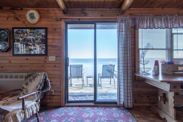interior space featuring a water view, beam ceiling, and wooden ceiling
