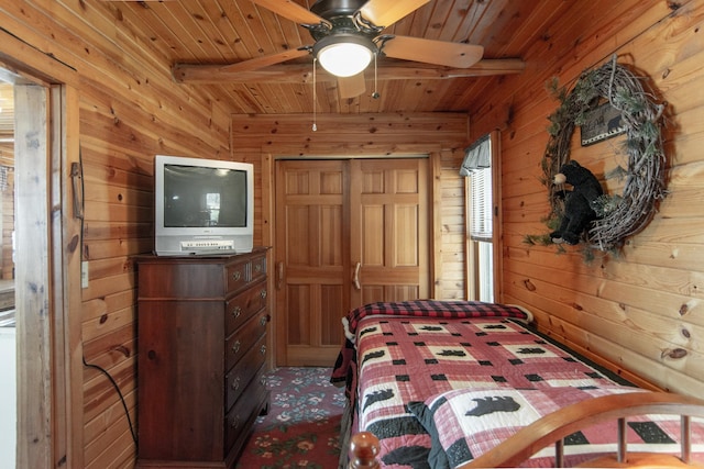 bedroom with wooden walls, beamed ceiling, wooden ceiling, and carpet flooring