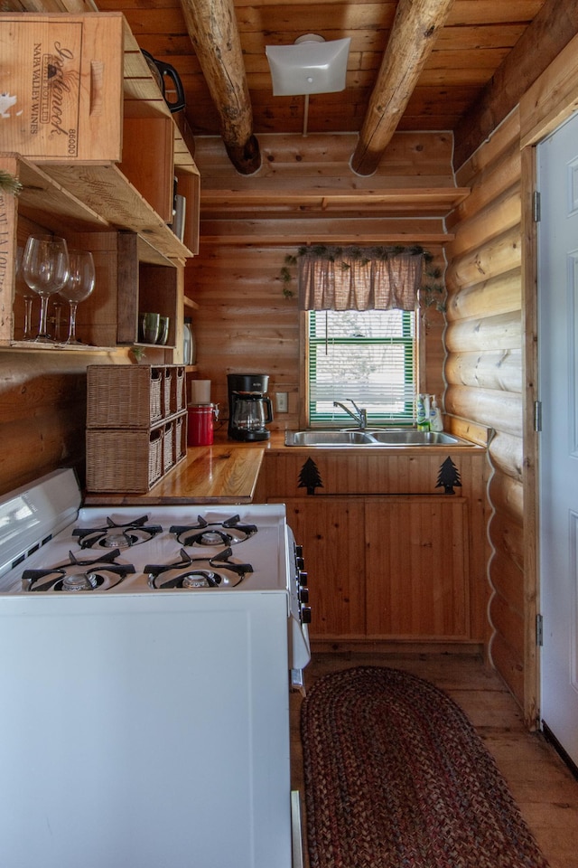 kitchen with a sink, rustic walls, light wood-style floors, wooden ceiling, and white gas range oven