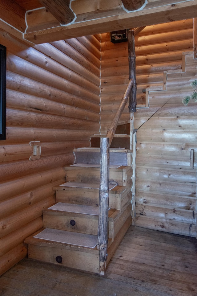 stairway with wood-type flooring and log walls