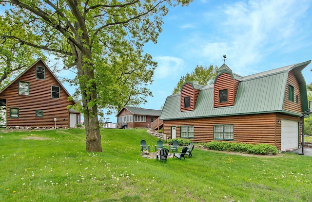 21594 452nd Pl, Aitkin, MN 56431 - rear view of house with a lawn, a fire pit, a gambrel roof, an attached garage, and metal roof