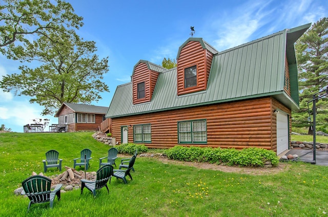 21594 452nd Pl, Aitkin, MN 56431 - back of house with metal roof, a garage, a yard, a fire pit, and a gambrel roof